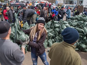 Tania Latulipe helps out with sandbagging at Rue Saint-Louis and Rue Moreau in Gatineau as flooding continues throughout the region in areas along the local rivers.