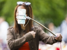 The selfie sticks were flying at Commissioners Park near Dow's Lake Monday May 22, 2017, as hundreds of people took photos by the tulips.  (Photo/Darren Brown) Assignment: 126664