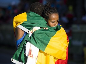 Women's winner Netsanet Gudeta hugs men's champion Leul Gebresilase after crossing the 10K race finish line at Tamarack Ottawa Race Weekend on Saturday, May 27, 2017.