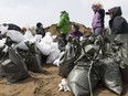 Volunteers work on a hill of sand at Constance Bay. The city is stil finalizing plans on how to deal with the sand and bags once the emergency is over.