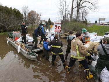 Volunteers load sand bags on a barge on Voisine Rd to fight off the flood from the Ottawa River in Rockland, May 09, 2017.
