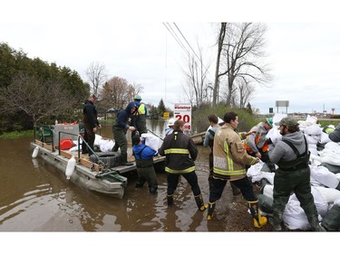 Volunteers load sand bags on a barge on Voisine Rd to fight off the flood from the Ottawa River in Rockland, May 09, 2017.