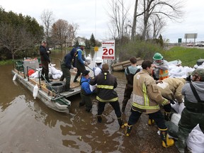 Volunteers load sand bags on a barge on Voisine Rd to fight off the flood from the Ottawa River in Rockland, May 09, 2017.  Photo by Jean Levac