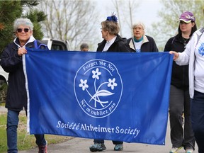 File photo of walkers holding up a banner during the Quinte West Walk for Alzheimer's at Centennial Park on Saturday May 13, 2017 in Trenton, Ont.