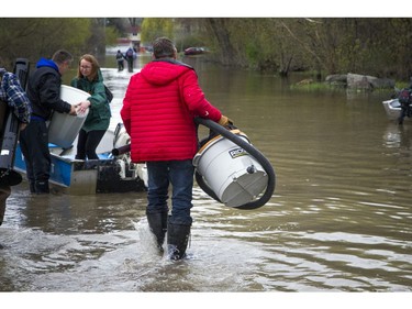 Water levels in Gatineau have started to come down in the flooding but major damage is starting to show Saturday May 13, 2017.  People walk in the water along Rue de Versailles.