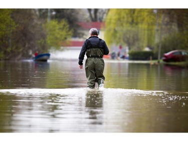 Water levels in Gatineau have started to come down in the flooding but major damage is starting to show Saturday May 13, 2017.  A man walks out in waders along Rue de Versailles.