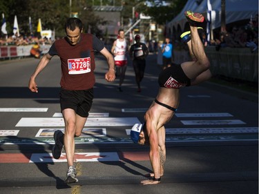 William Fortin does a cartwheel as he crossed the finish line of the 10K race.