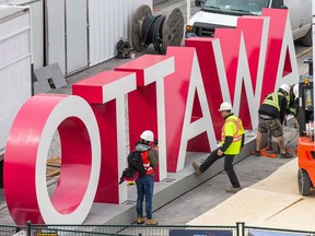 Workers are seen installing the OTTAWA sign at Inspiration Village on York St in the ByWard Market, part of the Ottawa 2017 celebrations, opening on May 20 and running until September 4.