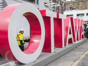 Workers are seen installing the OTTAWA sign at Inspiration Village on York Street in the ByWard Market earlier this year, part of the Ottawa 2017 celebrations.