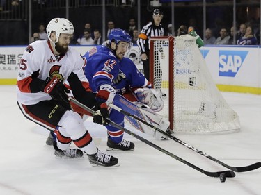 Ottawa Senators' Zack Smith (15) and New York Rangers' Brendan Smith (42) fights for control of the puck during the first period of Game 4 of an NHL hockey Stanley Cup second-round playoff series Thursday, May 4, 2017, in New York.