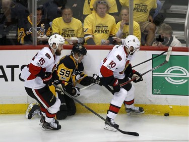 Ottawa Senators' Zack Smith (15) and Tom Pyatt (10) battle for the puck against Pittsburgh Penguins' Jake Guentzel (59) during the second period of Game 7 of the Eastern Conference final in the NHL Stanley Cup hockey playoffs in Pittsburgh, Thursday, May 25, 2017.