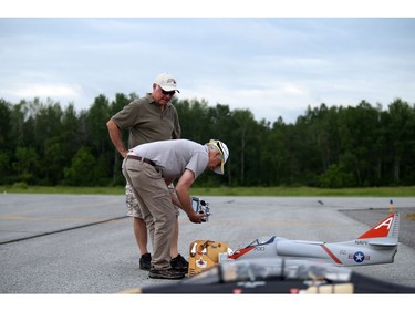 Pilots, spotters and spectators were at the Carp Airport to enjoy the miniature radio-controlled jet planes taking flight Saturday June 17, 2017. L-R Spotter Dave Penchuk and pilot Eric Dainty were getting the very old A4 Skyhawk, the only glow fuel ducted fan jet ready for flight Saturday.    Ashley Fraser/Postmedia
Ashley Fraser, Postmedia