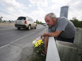 Jim Gibson lays flowers on a bridge in Kemptville on Sunday, June 18, 2017, where his friend Gary Boal was killed the night before while crossing.