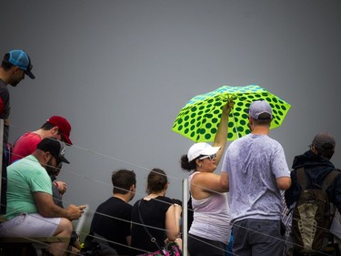 For the first time ever the Red Bull Global Rallycross made a Canadian stop over the weekend at the Canada Aviation and Space Museum. A woman starts to close her umbrella as the rain came to a stop as the dark clouds passed Sunday June 18, 2017.   Ashley Fraser/Postmedia
Ashley Fraser, Postmedia