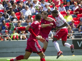 New York's Jordan Scarlett tugs at the jersey of Ottawa's Tucker Hume during the first half of Saturday's match at TD Place stadium.  Ashley Fraser/Postmedia