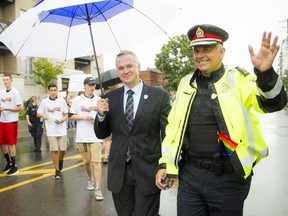 Matt Skof, president of the Ottawa Police Association, and Ottawa police Chief Charles Bordeleau make their way along the parade route during Capital Pride's 2016 parade.