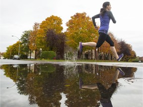 Lisa Hebert jumps over a puddle while out of a run after a morning shower in Gatineau.
