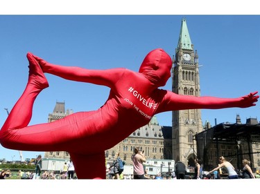 Coinciding with construction, yoga and over 165 students bringing attention to elder abuse, Canadian Blood Services were also out on Parliament's lawn for World Blood Donor Day, testing people's blood type and bringing attention to the need for blood donation.  Dressed as the lifeblood mascot, The Morph, Annie Barrette, stood out amidst the yoga practitioners as she stretched before yoga.