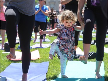 - Little Jane Amoureux, 2, gets a little help from her mom, Emily, while attempting some of the tricky yoga poses.