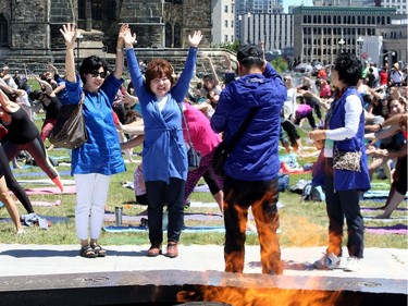 - Some happy tourists got into the action, stretching for the cameras in front of the Eternal Flame as the mass yoga class took place.