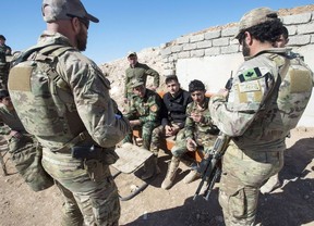 Canadian special forces soldiers, left and right, speak with Peshmerga fighters at an observation post, Monday, February 20, 2017 in northern Iraq.