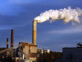FILE - In this Jan. 20, 2015 file photo, a plume of steam billows from the coal-fired Merrimack Station in Bow, N.H. President Donald Trump may abandon U.S. pledges to reduce carbon emissions, but global economic realities ensure he is unlikely to reverse the accelerating push to adopt cleaner forms of energy. (AP Photo/Jim Cole, File)