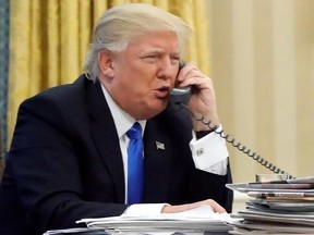 FILE - In this Jan. 28, 2017, file photo, President Donald Trump speaks on the phone with Prime Minister of Australia Malcolm Turnbull in the Oval Office of the White House in Washington. Trump, who blasted Hillary Clinton for using a personal email server, might be a walking magnet for eavesdropping and malware if he is using an unsecured cellphone to chat with foreign leaders. Trump has been handing out his cellphone number to counterparts around the world, urging them to call him directly to