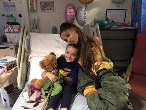 In this photo taken on Friday, June 2, 2017 provided by the Manchester Evening News, victim of the Manchester concert blast Lily Harrison hugs singer Ariana Grande during her vistit to the Royal Manchester Children&#039;s Hospital, in Manchester, England. Grande surprised young fans injured in the Manchester Arena attack, hugging the thrilled little girls in their hospital beds as they recovered from injuries sustained in the May 22 suicide bombing. (Manchester Evening News via AP)