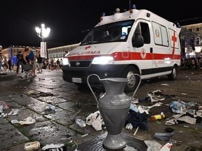 A mock replica of the Champions League trophy sits in front of an ambulance parked in San Carlo&#039;s square at the end of the Champions League final soccer match between Juventus and Real Madrid, in Turin, Italy, Saturday, June 3, 2017. Juventus fans watching the Champions League final rushed out of a Turin piazza in panic Saturday after witnesses reported hearing a loud sound. (Alessandro Di Marco/ANSA via AP)