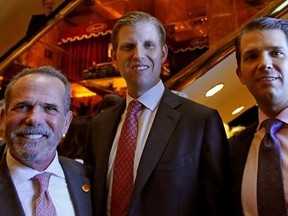 Eric Danziger, CEO of Trump Hotels, left, joins Eric Trump, center, and Donald Trump Jr., both of whom are executive Vice Presidents of The Trump Organization, as the trio poses for a photograph during an event for Scion Hotels, Monday, June 5, 2017, in New York. (AP Photo/Kathy Willens)