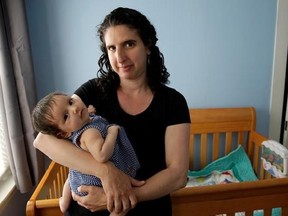 In this Thursday, June 1, 2017 photo Elena Tenenbaum holds her eight-week-old baby Zoe while standing for a photograph at their home, in Providence, R.I. Tenenbaum, a clinical psychology researcher, had her second daughter in April of 2017, and has been able to use Rhode Island&#039;s paid family leave program, which started in 2014 and covers four weeks of partial pay. (AP Photo/Steven Senne)