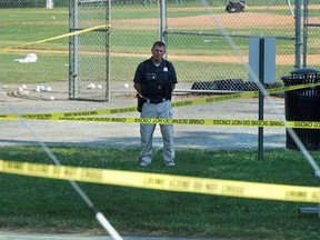 A police office stands watch behind police tape near strewn softballs on a field in Alexandria, Va., Wednesday, June 14, 2017, after a multiple shooting involving House Majority Whip Steve Scalise of La.