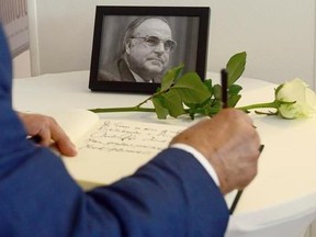 A delegate signs a condolences book for former German Chancellor and party chairman Helmut Kohl during a regional party convention of the German Christian Democratic Party (CDU) in Berlin, Germany, Saturday, June 17, 2017. Kohl died on Friday, June 16, 2017 at the age of 87. (Maurizio Gambarini/AP via dpa)