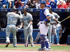 Chicago White Sox designated hitter Todd Frazier (21) celebrates after scoring on his solo home run with third baseman Matt Davidson (24) as Toronto Blue Jays catcher Luke Maile (22) looks on during second inning American League MLB baseball action in Toronto on Saturday, June 17, 2017. THE CANADIAN PRESS/Nathan Denette