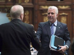 Quebec Premier Philippe Couillard, right, and Parti Quebecois Leader Jean-Francois Lisee, shakes hands at end of the spring session at the legislature in Quebec City on June 16, 2017. Quebec Premier Philippe Couillard will be in Washington, D.C., today for a one-day visit that will include a meeting with U.S. President Donald Trump&#039;s point man on trade. THE CANADIAN PRESS/Jacques Boissinot