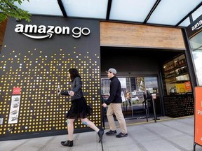 FILE - In this Thursday, April 27, 2017, file photo, people walk past an Amazon Go store, currently open only to Amazon employees, in Seattle. Amazon Go shops are convenience stores that don&#039;t use cashiers or checkout lines, but use a tracking system that of sensors, algorithms, and cameras to determine what a customer has bought. Amazon says the company has no plans to use such sensors to automate the cashier jobs at Whole Foods, which Amazon is acquiring. Still, it‚Äôs the kind of technology t