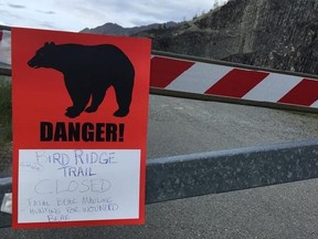 A sign warns people that the trail head is closed on Monday, June 19, 2017, after a fatal bear mauling at Bird Ridge Trail in Anchorage, Alaska. Authorities say a black bear killed a 16-year-old runner while he was competing in an Alaska race on Sunday.