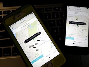 FILE - This Friday, Nov. 21, 2014, file photo taken in Newark, N.J., shows smartphones displaying Uber car availability in New York. Uber is enabling passengers to tip its U.S. drivers with a tap on its ride-hailing app for the first time, part of a push to recast itself as a company with a conscience and a heart. Besides the built-in tipping option announced Tuesday, June 20, 2017, Uber is giving drivers an opportunity to make more money when passengers keep them waiting or don‚Äôt cancel rides