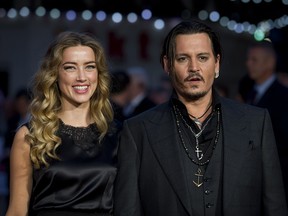 US actors Johnny Depp (R) and wife Amber Heard (L) pose for photographers on the red carpet for the premiere of Black Mass during the BFI London Film Festival in central London on October 11, 2015.