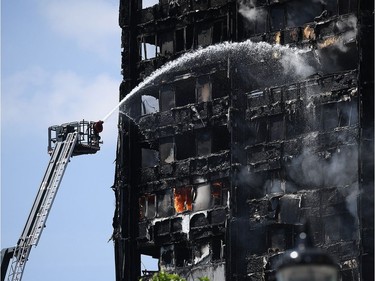 Fire fighters drench the burning 24 storey residential Grenfell Tower block in Latimer Road, West London on June 14, 2017 in London, England.  The Mayor of London, Sadiq Khan, has declared the fire a major incident as more than 200 firefighters are still tackling the blaze while at least 50 people are receiving hospital treatment.