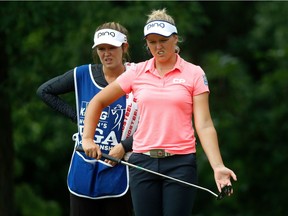 Brooke Henderson of Smiths Falls and her sister, Brittany, her caddy, read a putt on the 12th hole during Friday's round at Olympia Fields. Gregory Shamus/Getty Images