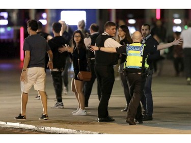 A police officer clears people away from the area near London Bridge.