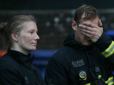 Firefighters react as a huge fire engulfs the Grenfell Tower early June 14, 2017 in west London.  The massive fire ripped through a 27-storey apartment block in west London in the early hours of Wednesday, trapping residents inside as 200 firefighters battled the blaze. Police and fire services attempted to evacuate the concrete block and said "a number of people are being treated for a range of injuries", including at least two for smoke inhalation.