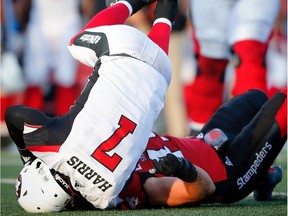 The Redblacks are concerned that QB Trevor Harris, shown being upended by Stampeders linebacker Alex Singleton, is spending too much time on the ground.