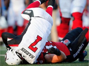 Redblacks QB Trevor Harris (7) is upended by Stampeders linebacker Alex Singleton during Thursday's game. AL CHAREST/POSTMEDIA