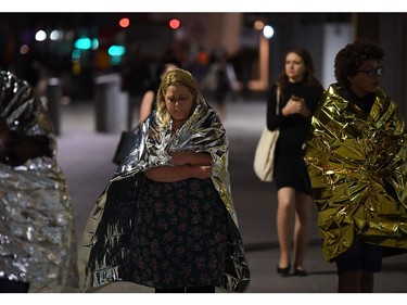 Members of the public, wrapped in emergency blankets, leave the scene of a terror attack.