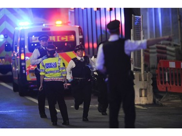 Police officers run at the scene of an apparent terror attack on London Bridge.