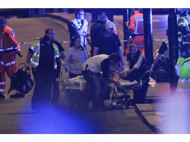 Police officers and members of the emergency services attend to a person injured in an apparent terror attack on London Bridge.