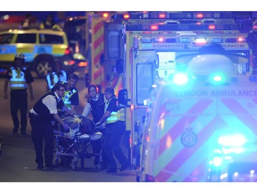Police officers and members of the emergency services attend to a person injured in an apparent terror attack on London Bridge.