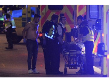 Police officers and members of the emergency services attend to a person injured at the scene of an apparent terror attack in London.